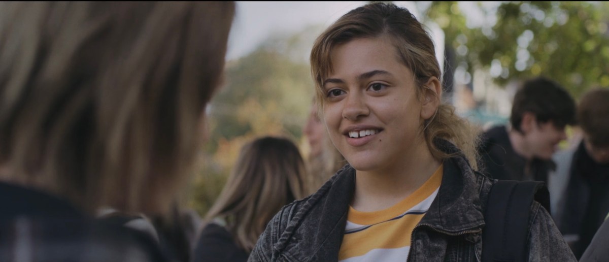 teenage girl in a ponytail, t-shirt and denim jacket, playing ALexa in "Modern Love"