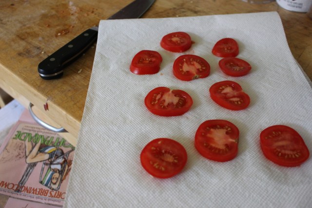 Setting tomatoes on a paper towel to soak up their liquid so the quiche doesn't get soggy!