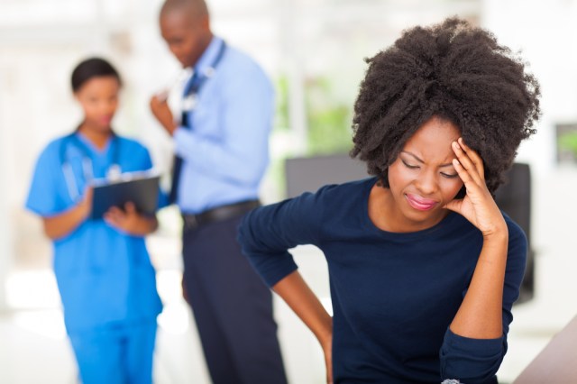 Black woman holding head.