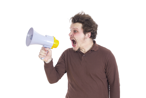 white man shouting into megaphone