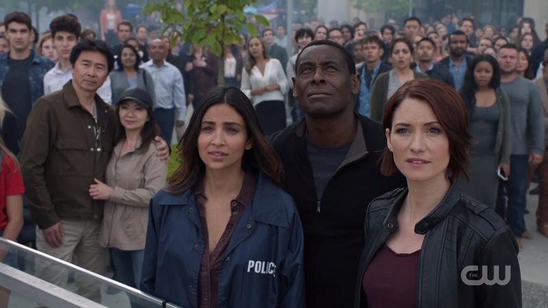 Alex, Maggie and J'onn look up proudly at Supergirl saving the day