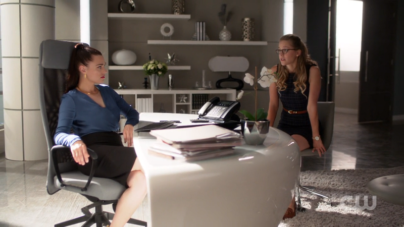 Lena slouches in her office chair and Kara sits across from her