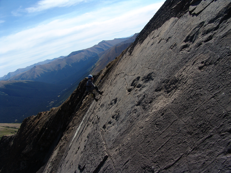 human on a steep incline with dinosaur prints