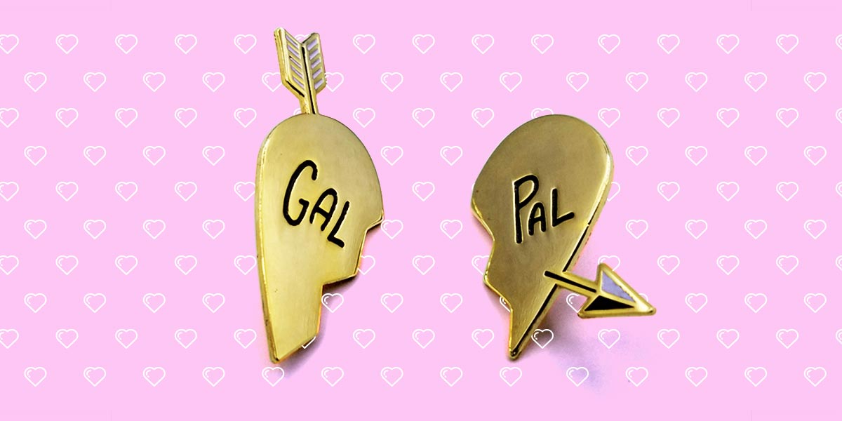 autostraddle merch gal pal enamel pin set gold heart halves that say "gal pal" with an arrow going through