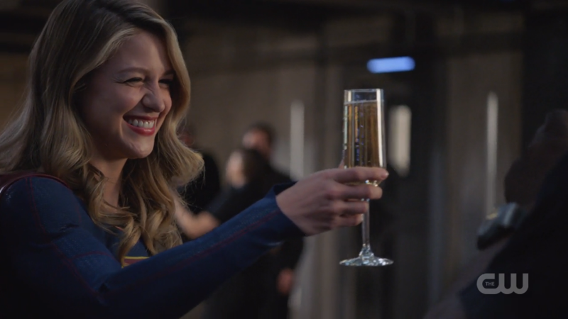 Kara raises a champagne glass