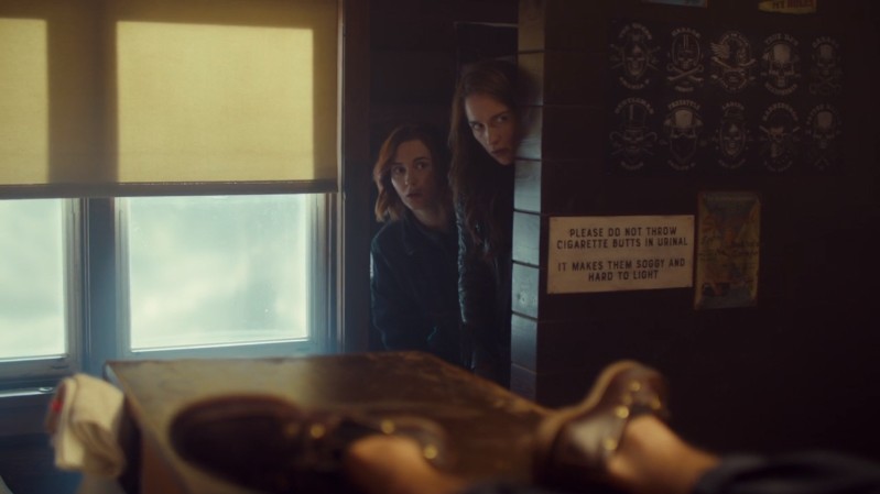 Nicole and Wynonna peek their heads from around a wall