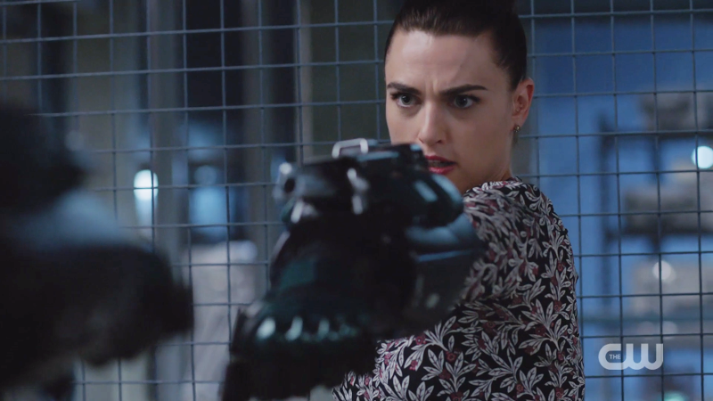 Lena holds up the suit's arm to shoot from it 