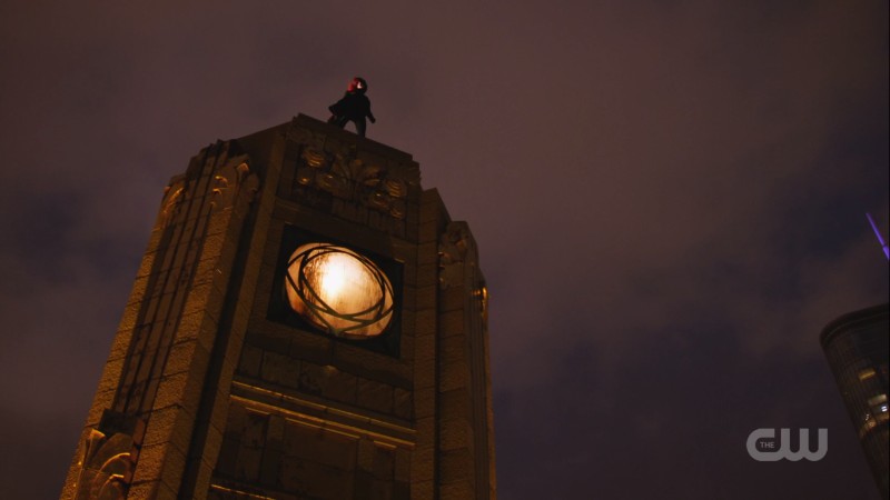 batwoman stands on a rooftop