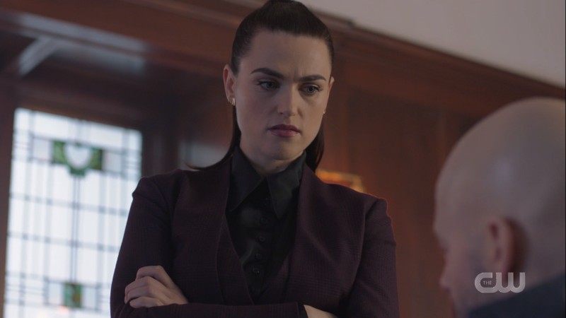 Lena crosses her arms in a suit