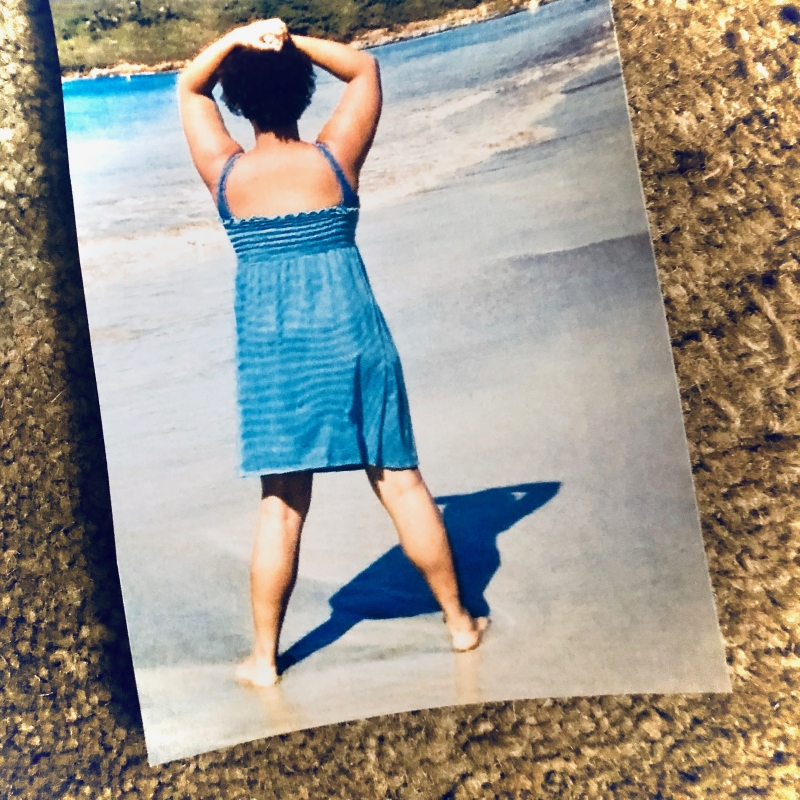 A photograph placed against a textured background of the author in a blue sundress in Puerto Rico