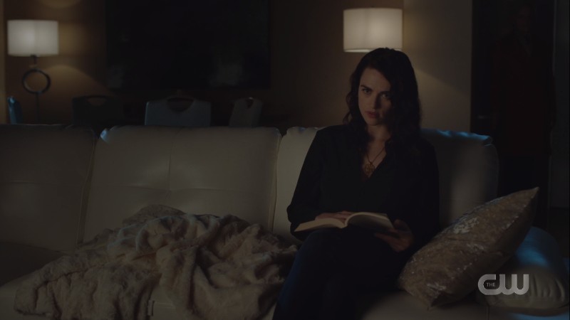 Lena sits reading in the dark 