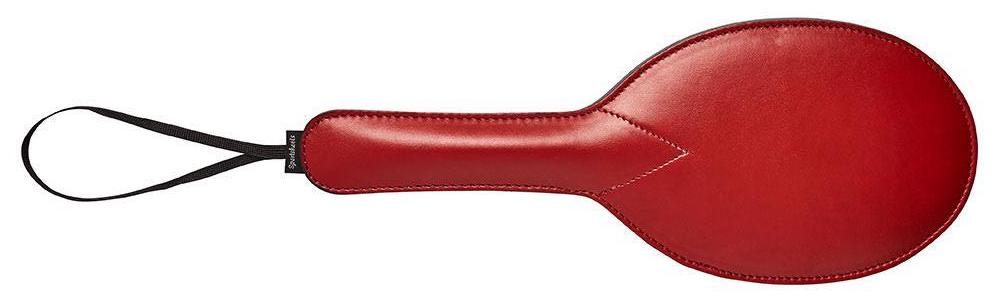 an oval red leather paddle with a loop for hanging