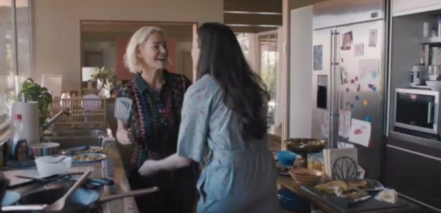 Alice holds a spatula in the kitchen with her girlfriend Nat