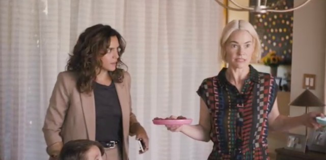 Nat's ex-girlfriend Gigi looks at Alice, who is shrugging while holding a pink plate