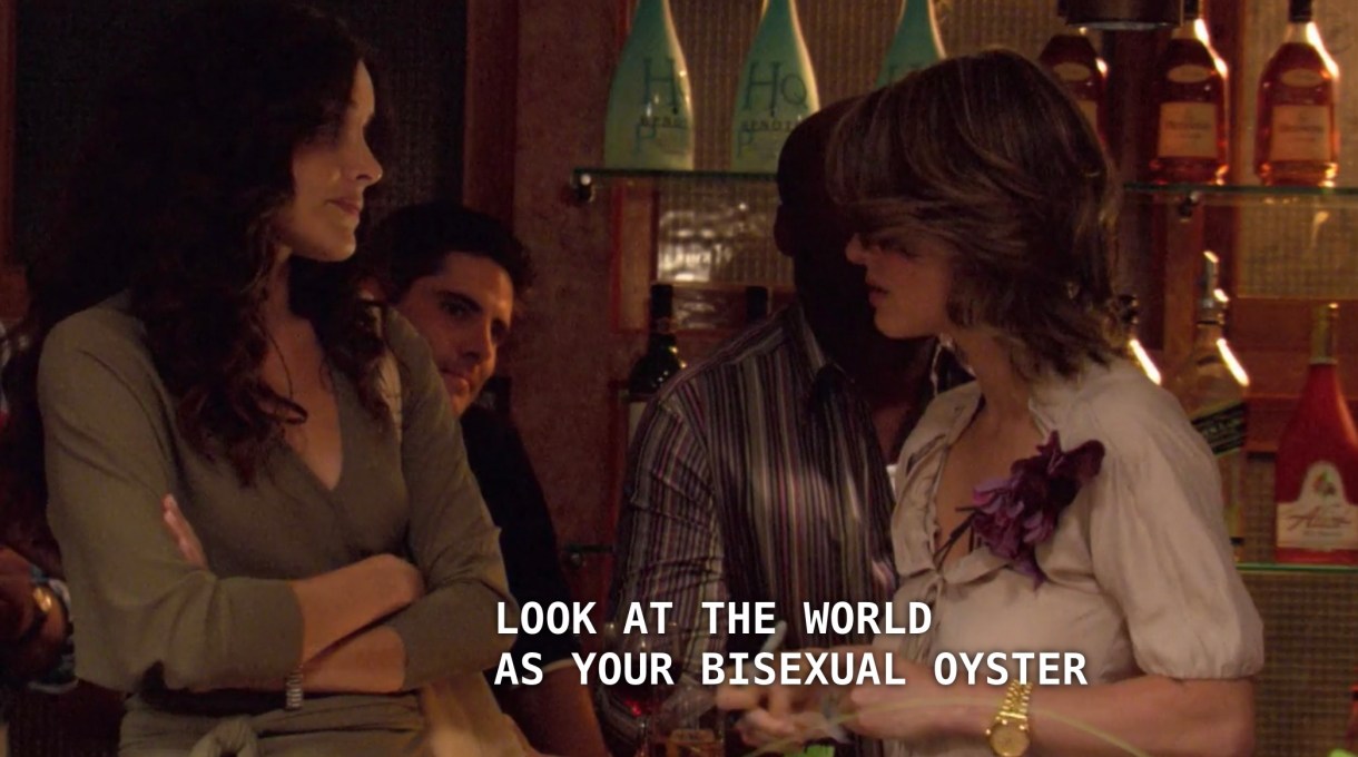 Alice (wearing a white satin blouse) is trying to convince Helena (wearing an olive deep-v dress) to stay and try out Bisexual Speed Dating. Alice tells Helena, "look at the world as your bisexual oyster."