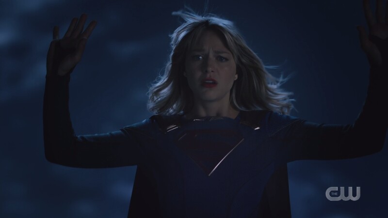 Supergirl holds up her hands in surrender