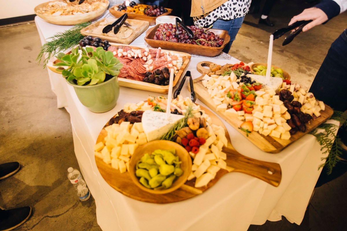 A photo of the food table, featuring multiple different meat and cheese plates. 