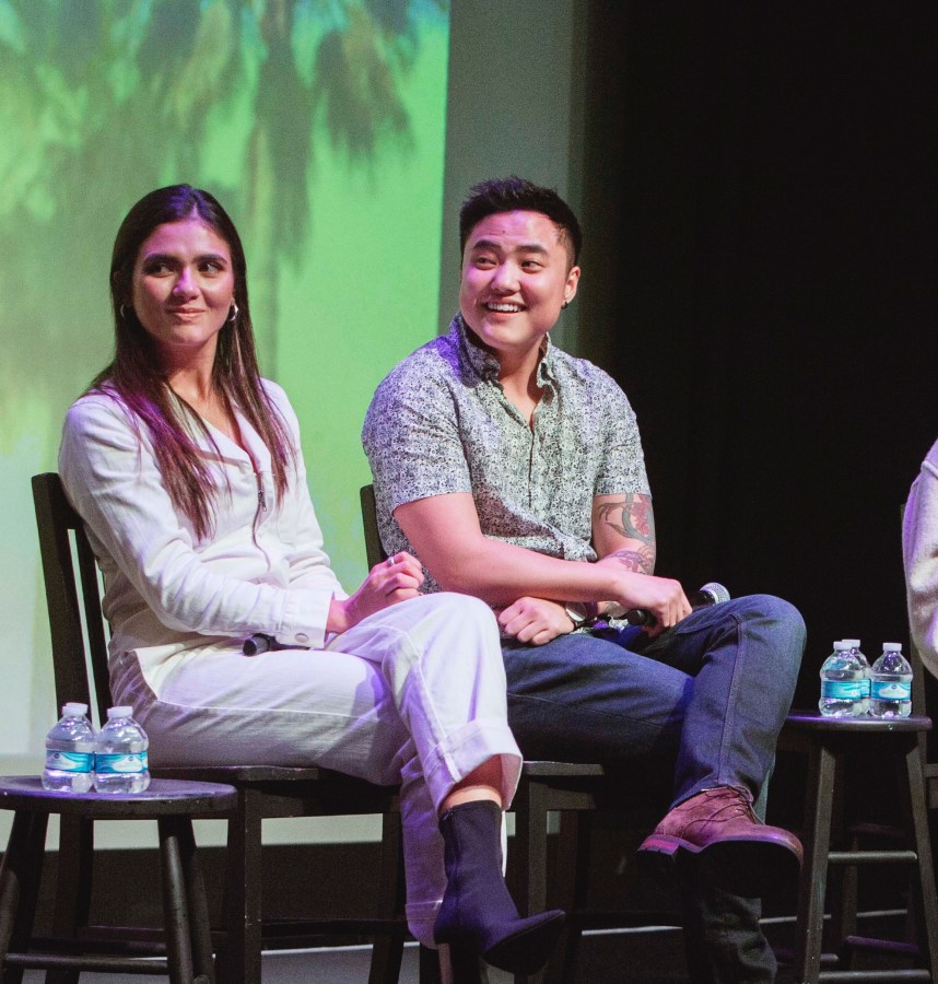 Arienne Mandi and Leo Sheng sit next to each other on stage. They are both smiling and looking to their right.