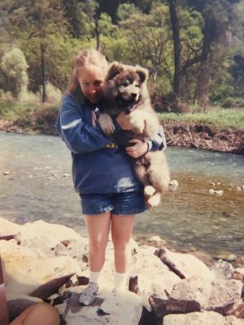 12 year-old Queer Girl holding an enormous fluffy gray puppy