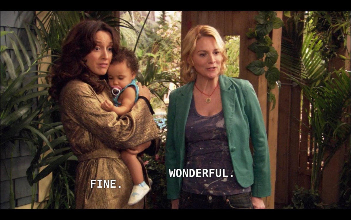 Bette (wearing a brown jacket) is holding Angelica (wearing a blue shirt and a pink pacifier) next to Tina (wearing a blue blazer) in their driveway. Bette says "Fine" and Tina says "Wonderful" to the adoption social worker (off camera) who has just arrived.