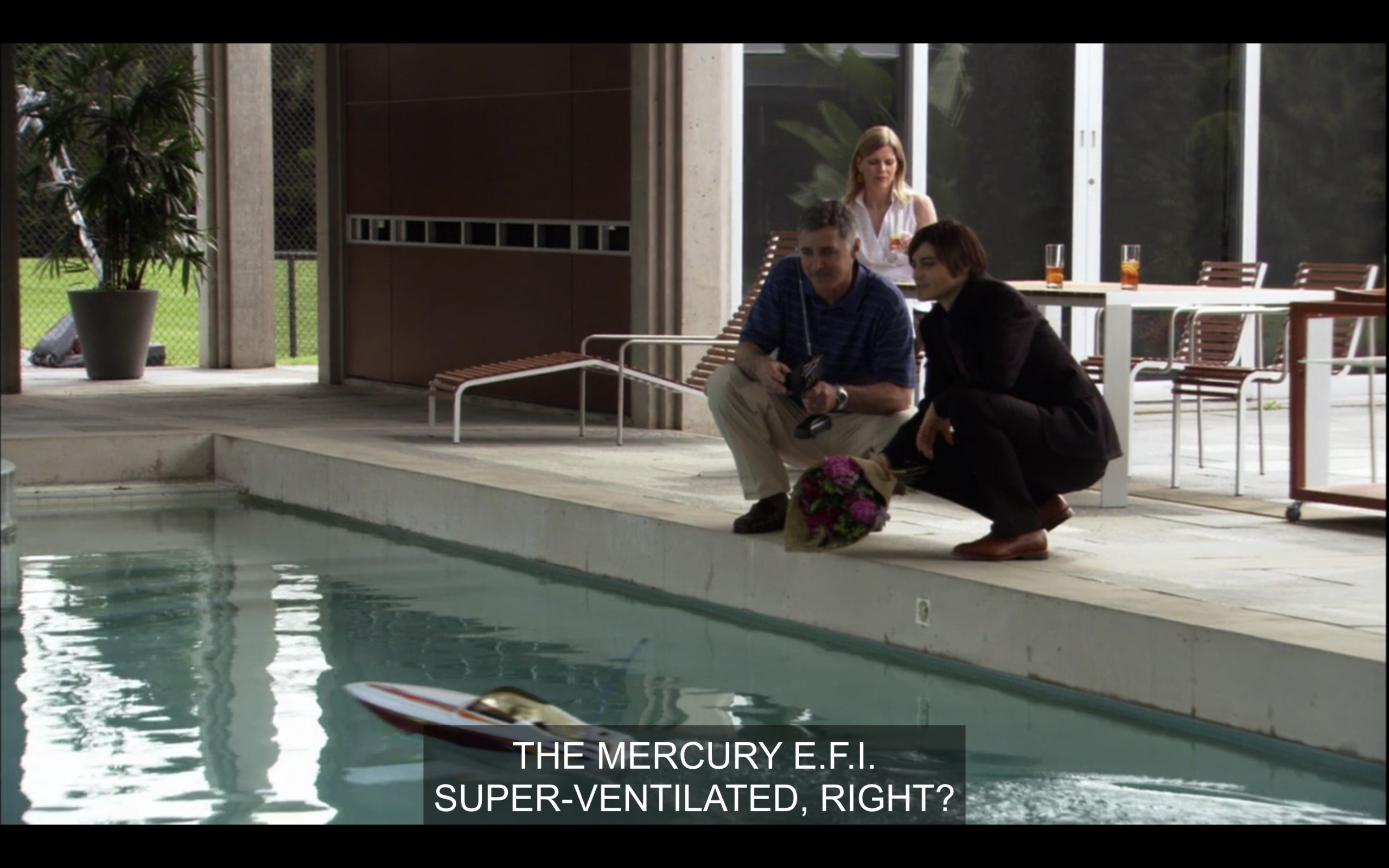 Max and his boss are driving a remote control boat in a pool. Max says, "The Mercury E.F.I. Super ventilated, right?"