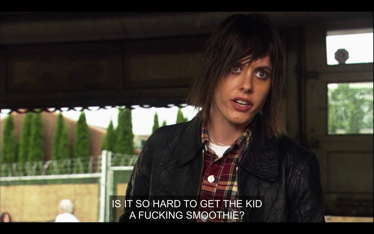 Shane wears a leather jacket and has a "what the fuck" look on her face. She says, "Is it so hard to get the kid a fucking smoothie?"