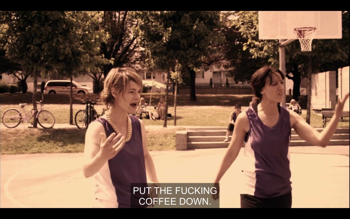 Alice and Bette on the basketball court. Alice yells at Jenny (who is off screen), "Put the fucking coffee down!"