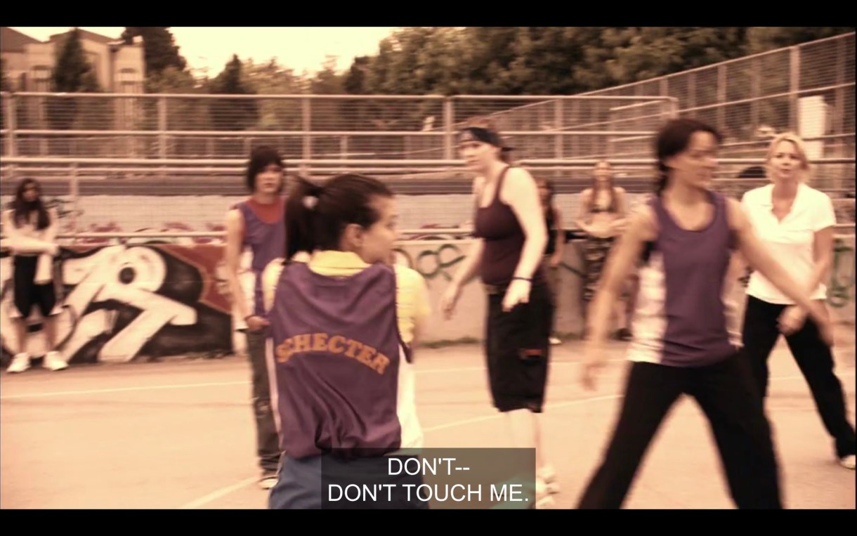 Jenny, Shane, Bette, Tina, and one of their opponents on the basketball court. Jenny has just grabbed the ball and says, "Don't touch me!"