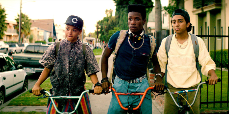 A lesbian and two boys stand with their bicycles. 