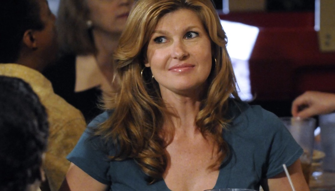 Tami Taylor in a teal v-neck at what looks like a team celebration at a bar