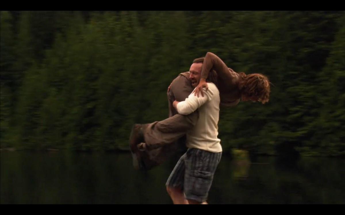 A terrible man carries Bette on his shoulder, about to throw her into the lake