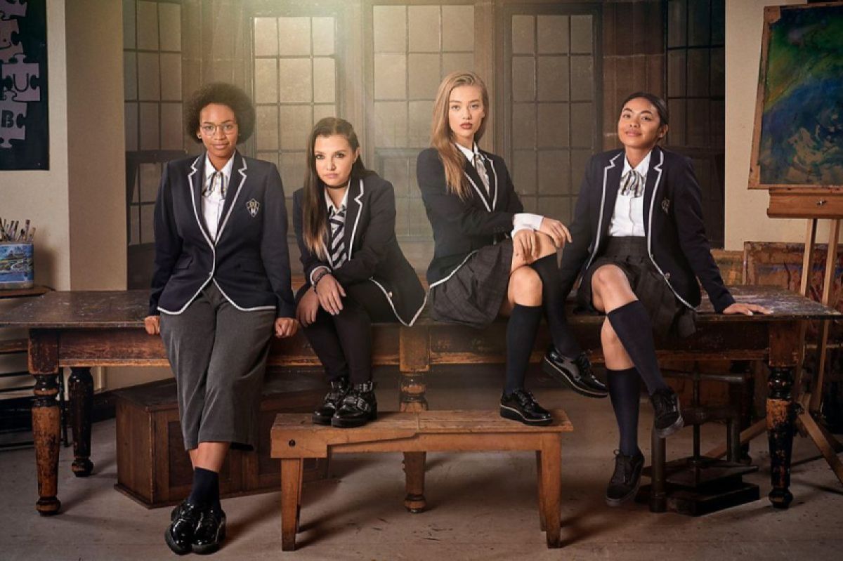 Four girls in school uniforms sit on a table in a smoky room: Margot (Black, wearing glasses and short pants), Bree (white, with a half-braided hair situation), Olivia (your standard white blonde blue-eyed pretty girl) and Kitty (athlete, ponytail, skirt)