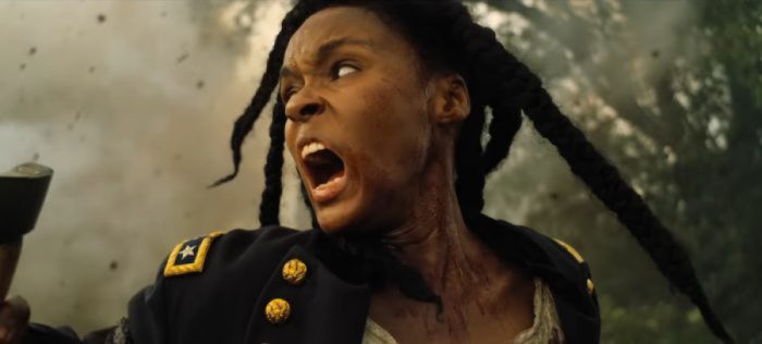 Janelle Monáe in "Antebellum" as the character Eden. Eden screams in anger, her face in profile to the camera, as smoke from torches fill the screen behind her.