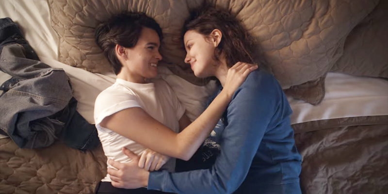 Brianna Hildebrand as Elodie Davis and Chloë Levine as Jillian snuggled up in bed in Trinkets season two.