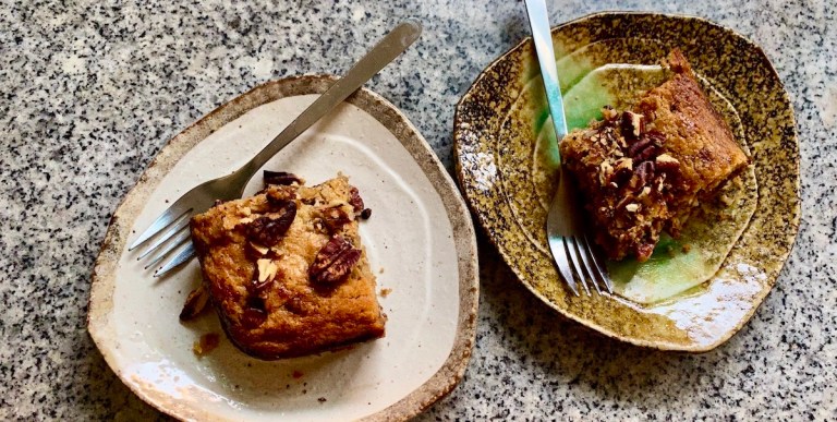 two ceramic plates with rectangles of pecan-covered blondie bars, with small forks sticking off of the sides.