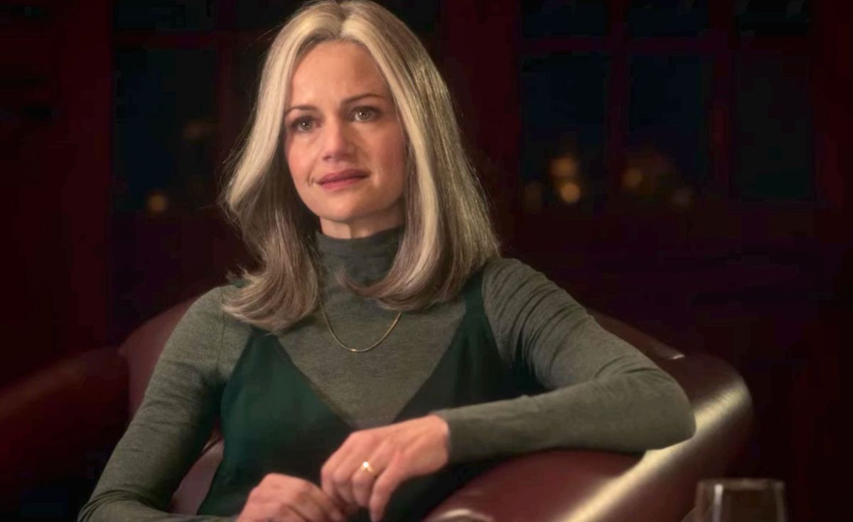 Carla Gugino wearing a gray wig and reclining in a chair during her appearance in Haunting of Bly Manor