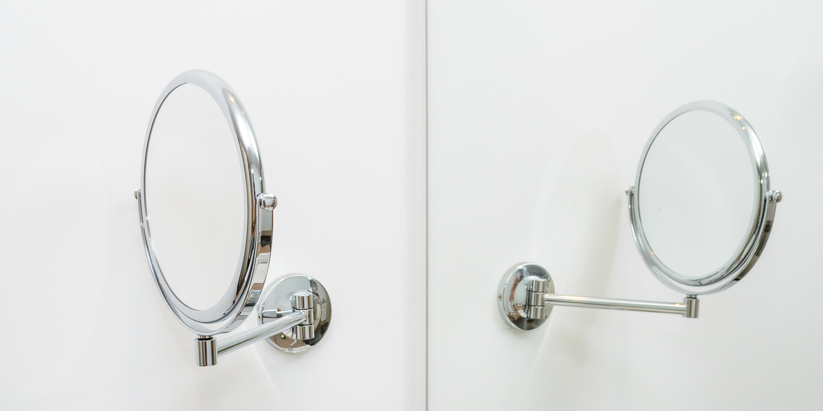 A magnifying mirror reflected in a wall mounted bathroom mirror