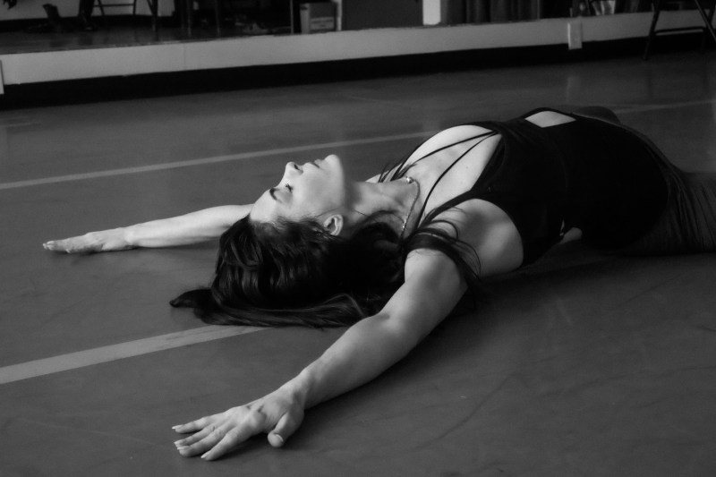 Anne Hathaway lies on the floor of a dance studio in a black and white image