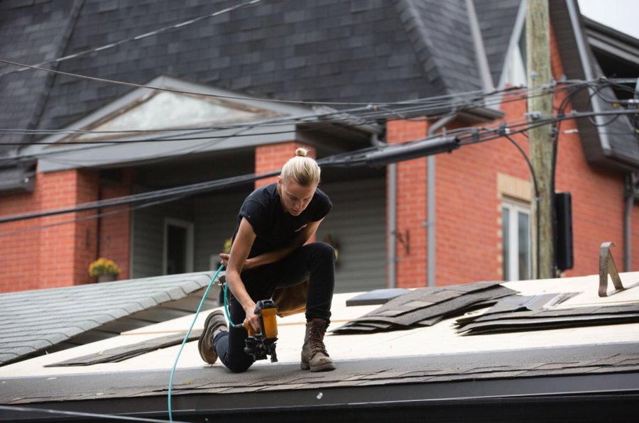 A scene from Below Her Mouth where Erika Linder is knelt on a roof with a power tool