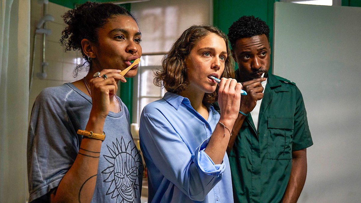 two women and one man brush their teeth together