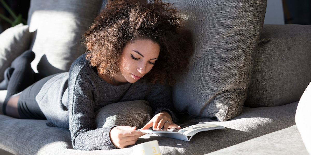 someone reading on a couch in the sun