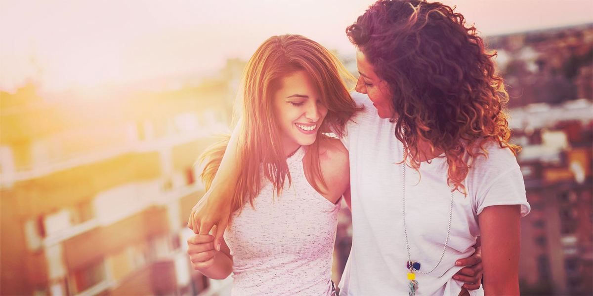 Two women embracing in the sunset.