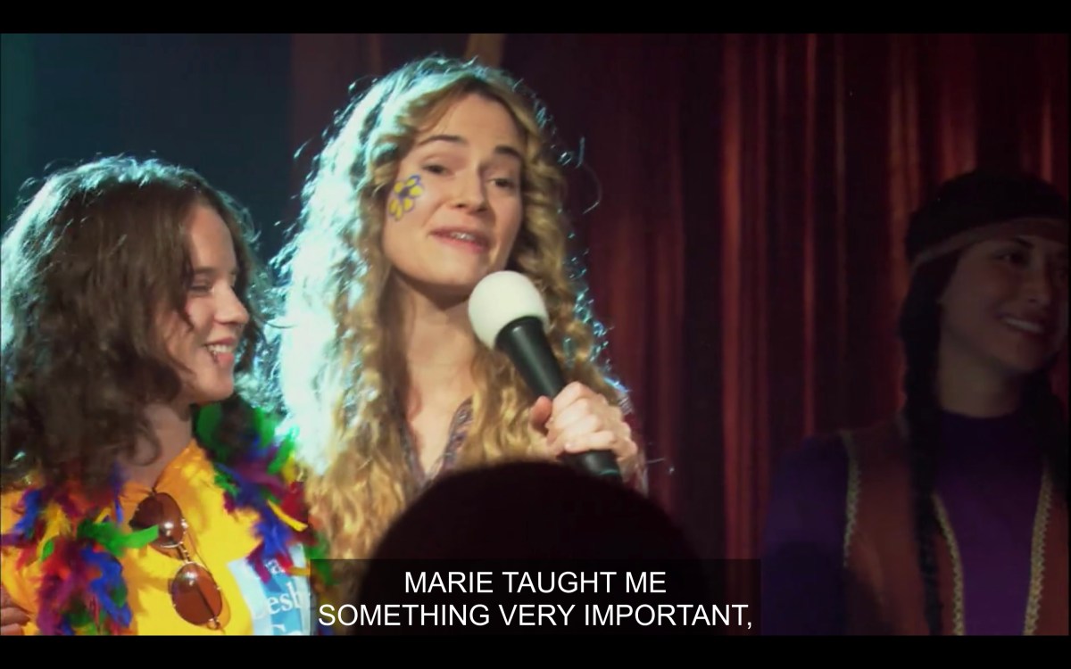 Alice on stage at the benefit with Marie saying Marie taught her something very important