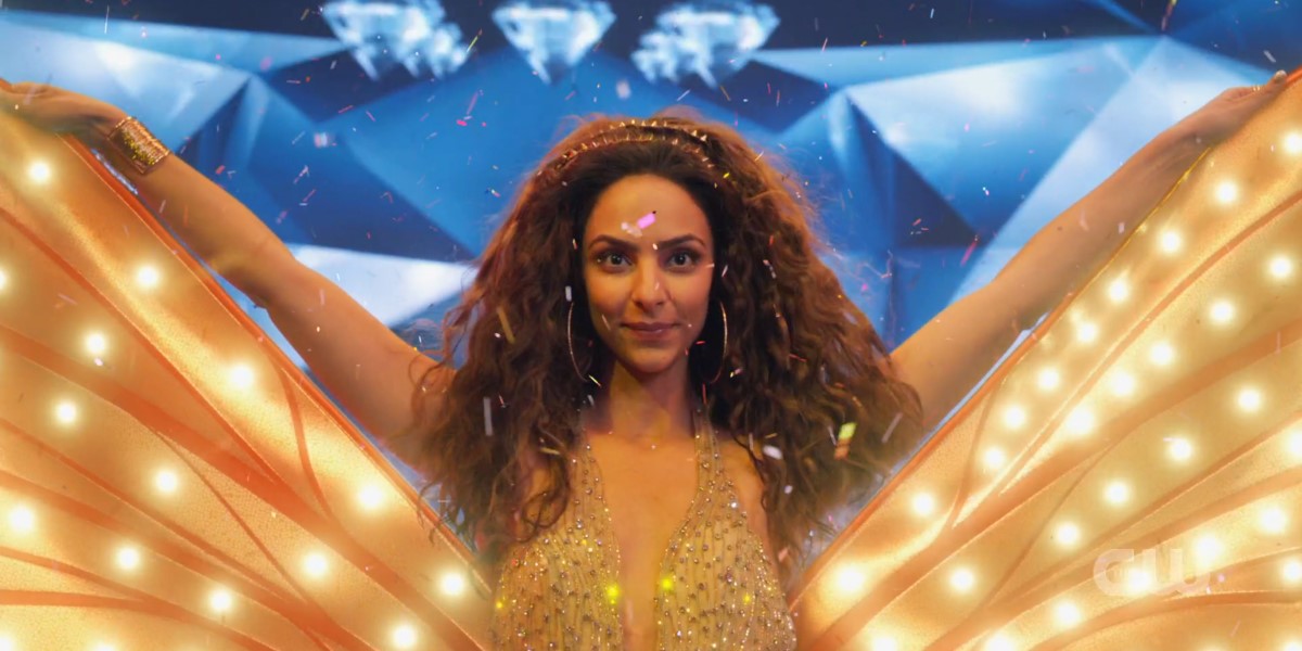 Screenshot from Legends of Tomorrow Episode 603: Zari is surrounded by glitter and extending costume wings at the end of a singing performance.