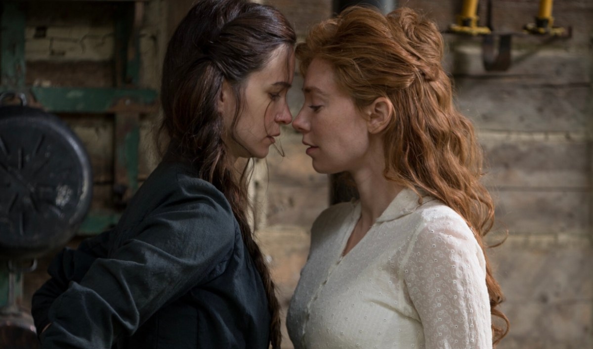 two women in period costume intensely stare at each other's eyeballs