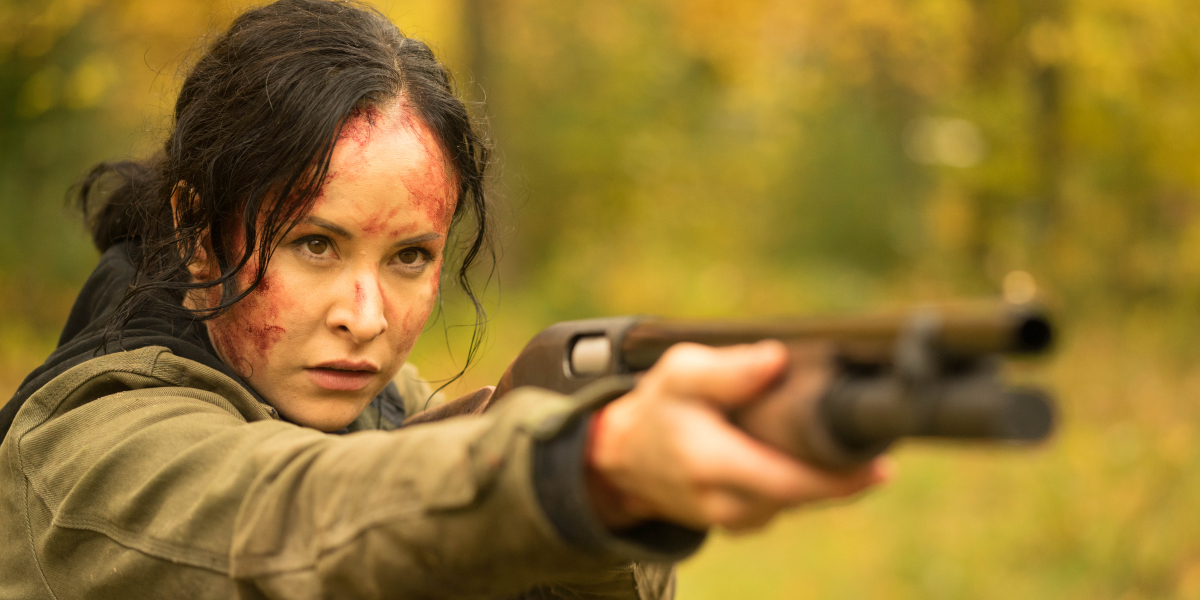 Tommie-Amber Price as Renee with blood on her face pointing a shotgun