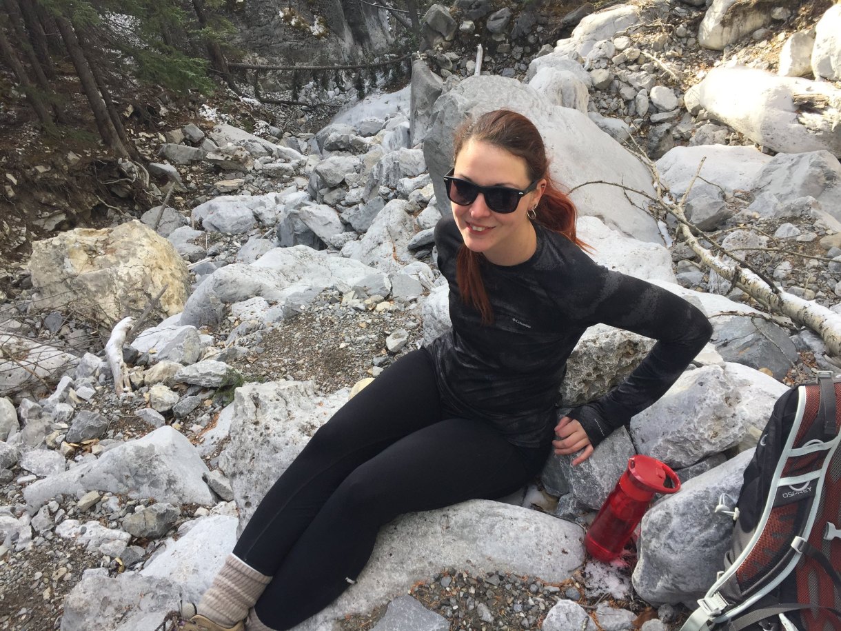 Rachel wearing all black and sitting on some rocks