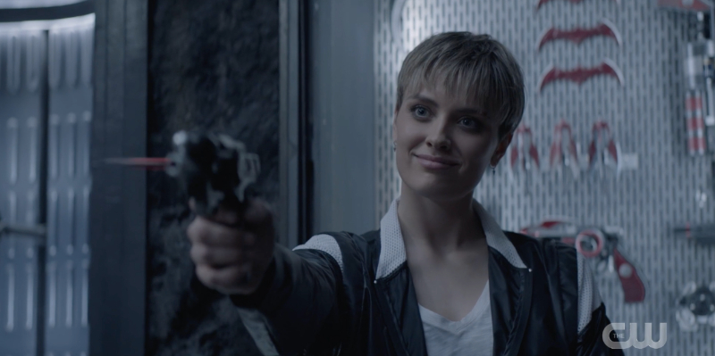 Wallis Day points a gun in the Batcave