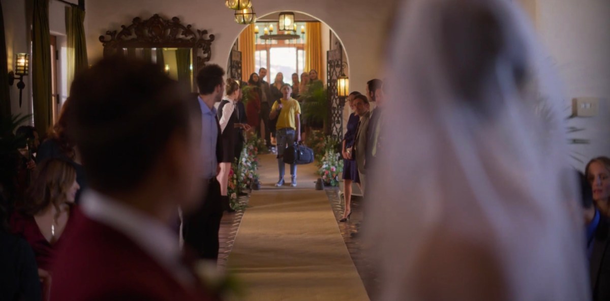 Finley standing at the other side of the wedding room with her duffel bag