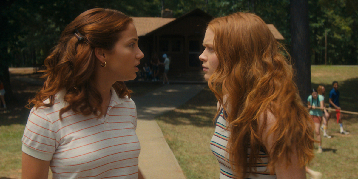 Fear Street's gay characters look alarmed in the foreground as a late 70s summer camp looms in the background